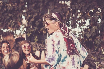 crazy blonde young woman and girls in friendship all together celebrating and having fun in a bio natural place. smiles and laughing for group of hippies people alternative concept lifestyle