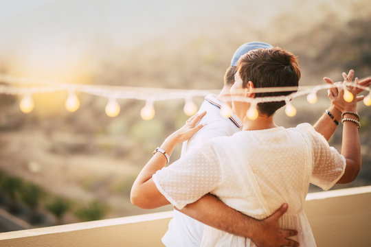 beautiful couple dancing on the terrace rooftop with natural view. love and dating concept for people having romantic leisure activity together with love and tenderness. foreverness concept and sunset