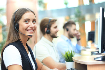 Attractive positive young businesspeople and colleagues in a call center office.