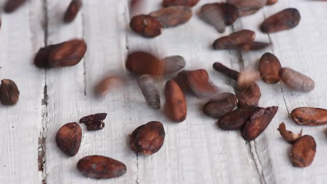 Delicious aromatic brown roasted cocoa beans on a white table