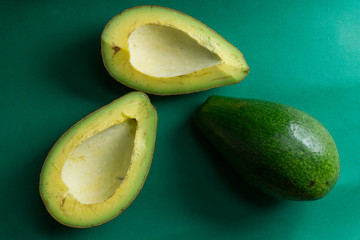Freshly cut avocado on a green background