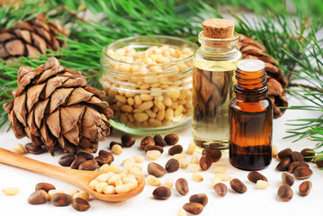 Dropper bottles with aromatic pine nut oil with cedar cones, fresh needled twigs, seeds. Healthy lifestyle. 