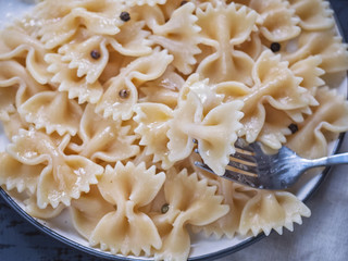 Pasta with grated cheese on a dark background, cutlery