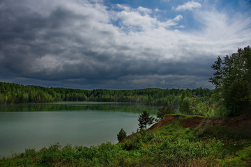 Fototapeta na wymiar Russia. The South Of Western Siberia. Flooded quarry for copper mining, the increased content of which in the water gives it a blue-green color