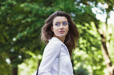 Fototapeta premium Beautiful woman in glasses walking in park