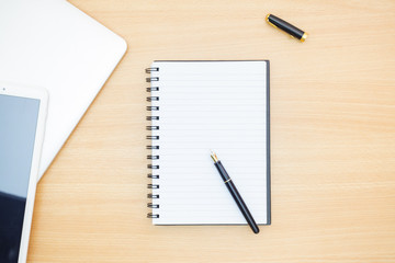 Flat lay photography. Empty notebook and a pen on a wooden table. Write memo office idea concept.