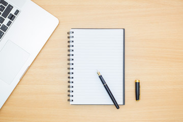 Flat lay photography. Empty notebook and a pen on a wooden table. Write memo office idea concept.