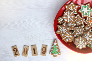 decorating festive table 2019 / Gingerbread in the shape of decorated Christmas tree and red bowl full of figured baking top view