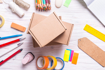 Set of cardboard boxes and stationery on wooden background, top view