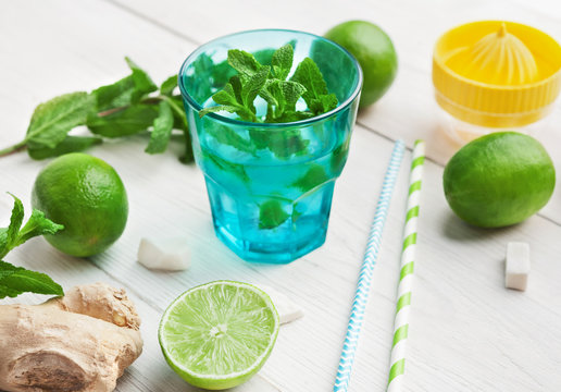 Lime and mint cocktail on wooden table.