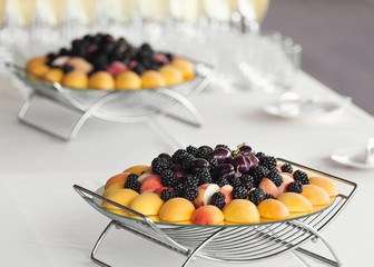 Trays with fresh fruits on table on wedding party
