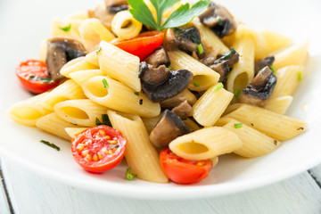 Piatto di pasta con funghi e pomodori ciliegini 