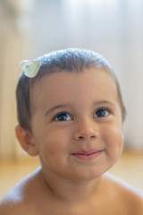 white butterfly on the head of a baby. Happy little boy with a butterfly on his head. vertical photo