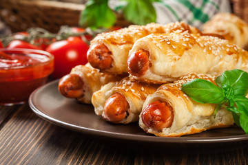 Rolled hot dog sausages baked in puff pastry