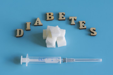 Diabetes, sugar and syringe on a blue background