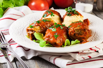 Stuffed cabbage with meat and rice served with boiled potatoes and tomato sauce