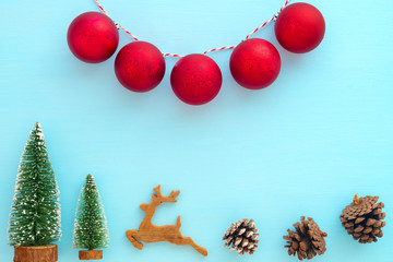 Christmas and New Year background.  Christmas tree, reindeer, pine cones and red balls on blue background. Creative flat lay, border and  top view design