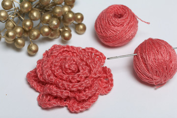 Ornaments made by own hands. On the table lies tangle of threads, a barrette and a knitted brooch...