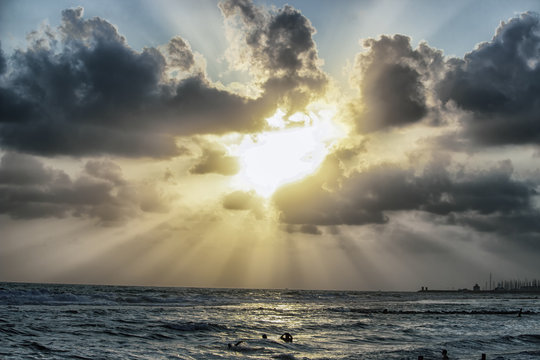 Sun beams trough the clouds in a cloudy sunset