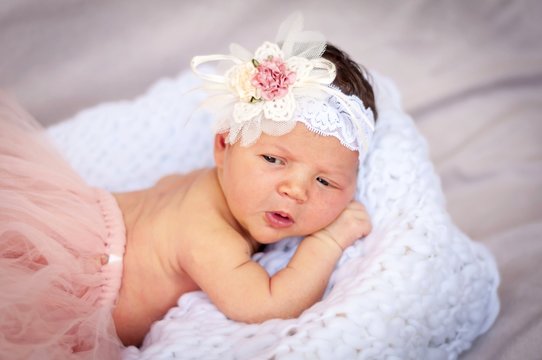 Cute tiny newborn baby princess in a ballet skirt with a bow on a basket with plaid. Soft tones. Adorable newborn infant girl stock image.