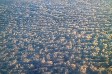 Sea of clouds in the sunlight, breathtaking view from airplane window during the flight 
