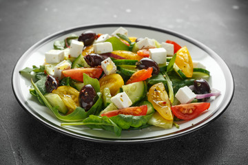 Fresh Greek salad with cucumber, cherry tomato, lettuce, red onion, feta cheese and black olives. Healthy food