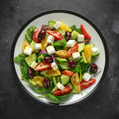 Fresh Greek salad with cucumber, cherry tomato, lettuce, red onion, feta cheese and black olives. Healthy food
