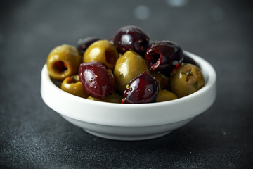 Black, Green Olives with herbs in white bowls