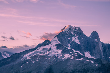 Fototapeta premium Karmazynowy wschód słońca nad Mont-Blanc Śnieżne szczyty i lodowce z chmurami