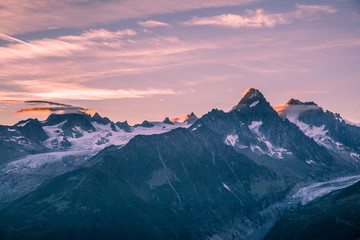 Fototapeta na wymiar Crimson Sunrise over Mont-Blanc Snowy Peaks and Glaciers with Clouds