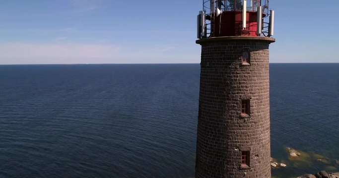 Lighthouse, C4K aerial rising drone view of a tall lighthouse, on a rocky island bengtskar, on a sunny summer day, in saaristomeri national park, Varsinais-suomi, Finland