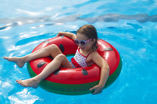 Child with watermelon inflatable ring swim pool