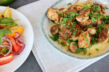 mashed potatoes with fried mushrooms and chicken on a side dish with tomatoes.