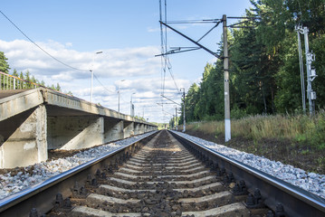 A view at the and railroad sleepers going through the forest