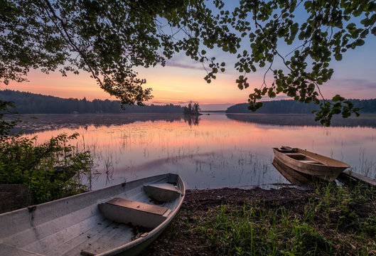 Scenic Sunset View With Two Row Boat And Idyllic Lake At Summer Night In Finland