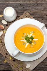 Pumpkin soup in a saucepan on a wooden table.