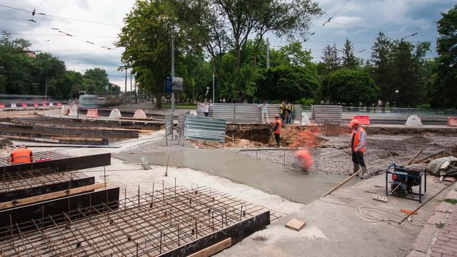 Concrete works for road maintenance construction with many workers and mixer timelapse