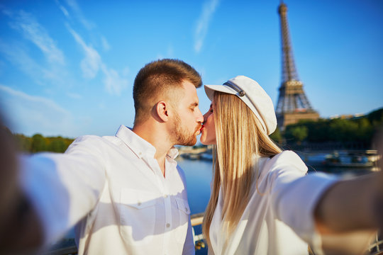 Happy couple taking selfie near the Eiffel tower
