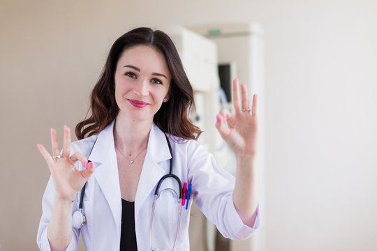 Portrait of the young beautiful breast specialist who is standing in her office and showing gesture
