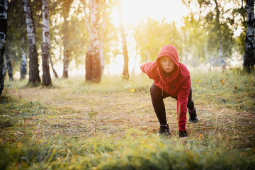 Naklejka na ściany i meble Focused woman exercising in the city park. Sports.
