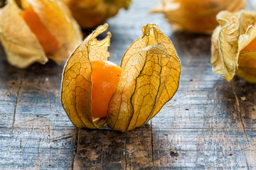 Physalis fruit (Physalis Peruviana) with husk on wooden background - closeup