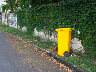 Obraz premium Yellow bins are placed on the side of the road in the village. Trash is for people in the village for left the garbage waiting to be Sorting for recycling.