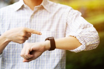 young man stand wait looking forward to timer  watching the clock. meeting make an appointment within the time limit concept. wristwatch	