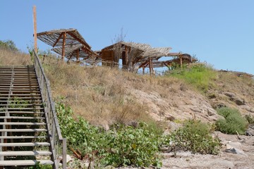 Fototapeta premium Stairway to heaven - a beach bar with umbrellas over the sea