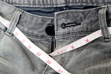 Jeans black and measuring subject for weight loss.
