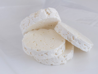 Feta cheese rounds stacked on white parchment paper