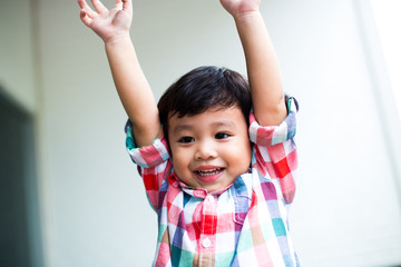 outdoor portrait of a cute little asian boy smiling in the park