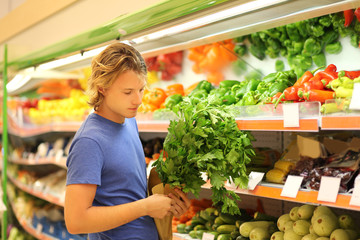 Young man buying vegetables at the market