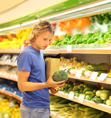 Young man buying vegetables at the market