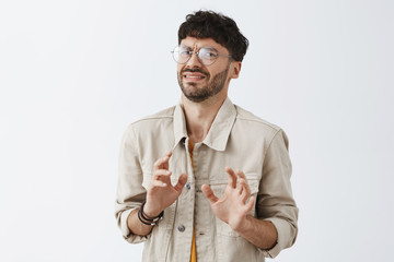 Waist-up shot of intense displeased snob guy with beard and dark hair bending backwards raising...